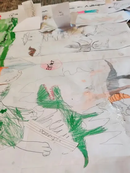 A section of the evolution timeline depicting a dinosaur. The children's drawings are full of energy and detail, reflecting their deep engagement with the story of life on our planet.