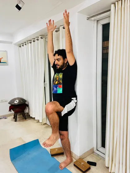 Using a wall for support in this standing balance pose helps cultivate mindfulness. It allows you to focus on your breath and the present moment without the added challenge of maintaining balance on your own.