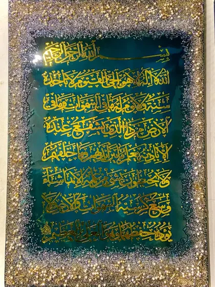 A close-up of the emerald green Ayat al-Kursi piece, showing the texture and sparkle of the border.
