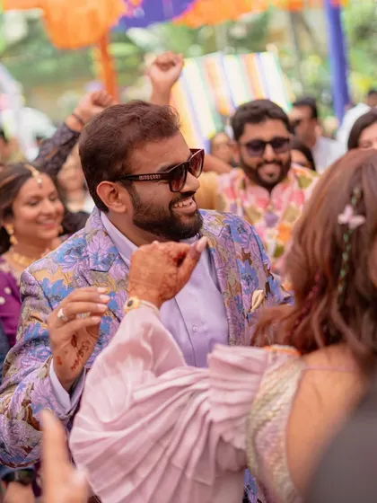A happy, candid moment of the couple dancing at their Mehendi. The energy and joy of the celebration are perfectly captured in this shot.