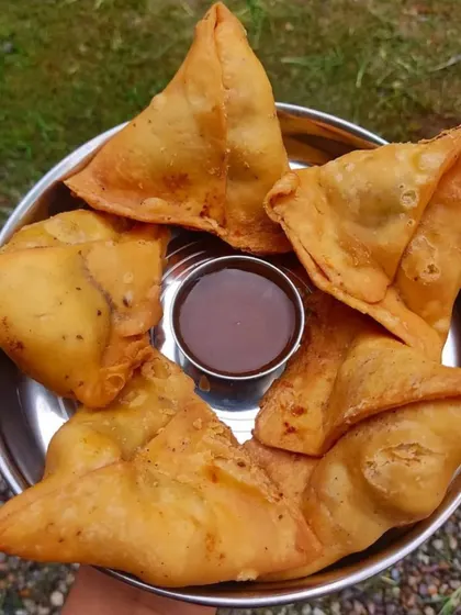 You can't go wrong with classic, hot samosas. Mine have a crispy, flaky pastry and are filled with a spiced potato and pea mixture, served with a tangy tamarind chutney for dipping.