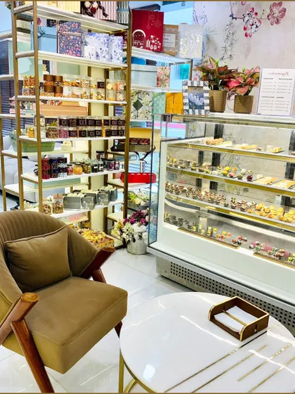 A cozy corner of our showroom, featuring a display of our gourmet products and a comfortable seating area for consultations. We also have a refrigerated display for our fresh sweets and chocolates.