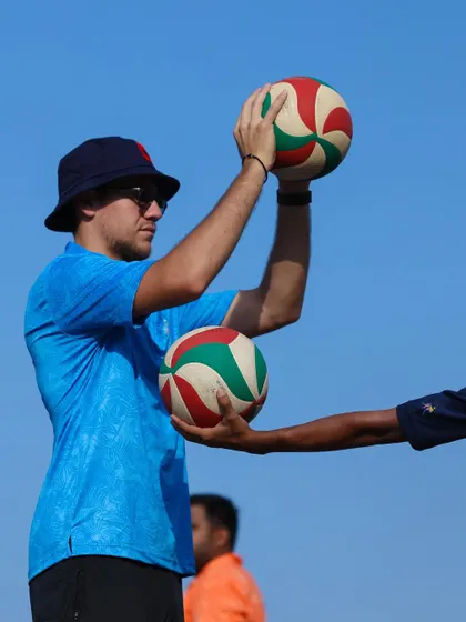 Guiding a player's hands to teach the feel of a proper set. This tactile coaching helps build muscle memory.