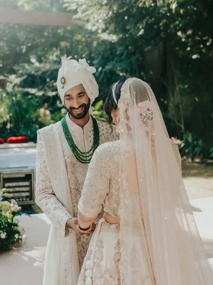 The groom's loving gaze as he sees his bride. This over the shoulder shot focuses on the emotional connection and the beautiful details of the bride's veil and hair.