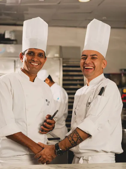 A candid, happy moment between two chefs in the kitchen at Yauatcha. This photo captures the camaraderie and positive energy behind the scenes, adding a layer of authentic, human storytelling to the brand.