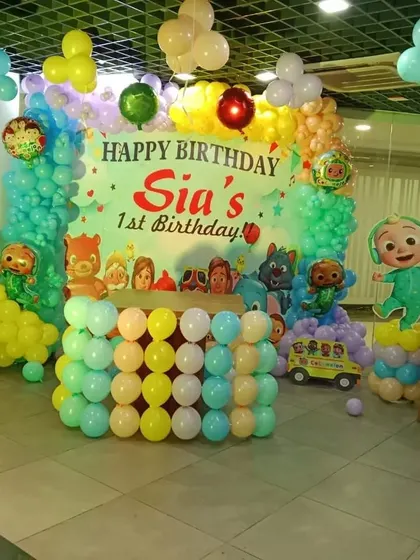 A Cocomelon first birthday setup in a restaurant, showing how I can adapt themes to different venues.