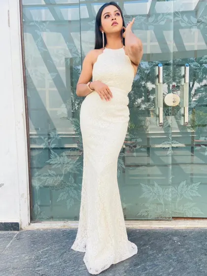 This full-length shot shows the elegant mermaid cut of the white lace gown.