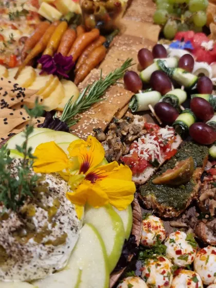 Our Jalepeno and Tallecherry Pepper Cream Cheese Ball sits among crackers, grapes and savoury bites on this party platter.