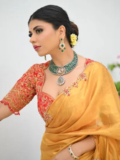 A detailed view of the red hand-embroidered blouse, a masterpiece of craftsmanship that elevates the entire look.
