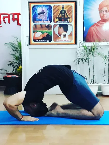 A student in a deep expression of Ushtrasana (Camel Pose). This backbend opens the heart center and improves posture.