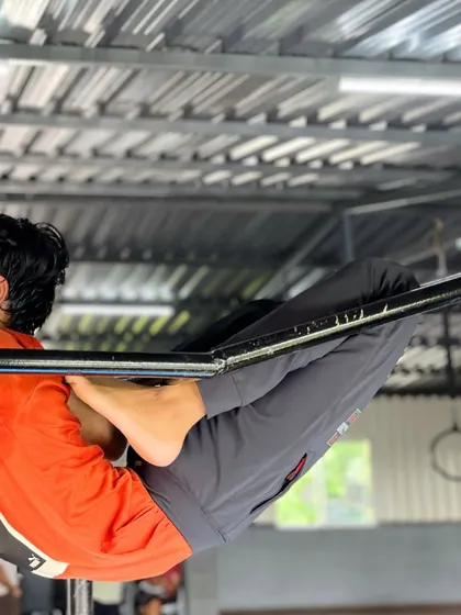 Your body is your greatest asset. This student demonstrates a tuck hold on the bars, a foundational exercise for developing upper body and core power.