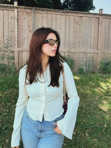A simple and clean college outfit with a white button-up and light-wash jeans.