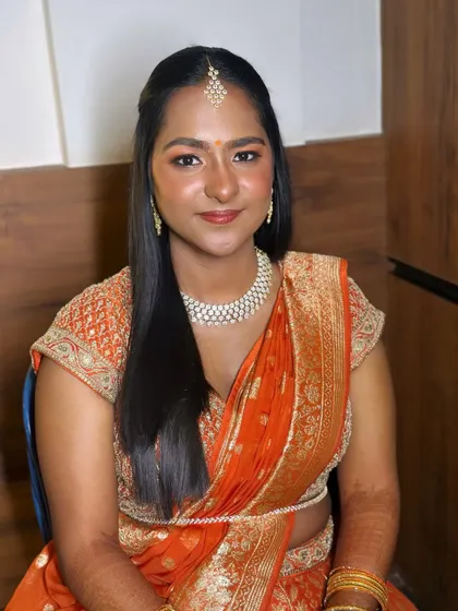 A radiant smile completes any bridal look. Here, the dewy foundation and soft, shimmering makeup catch the light, creating a flawless glow that feels natural and looks stunning.
