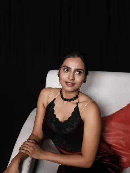 A candid, looking-away shot that gives a closer view of the dress's neckline and the model's choker accessory.