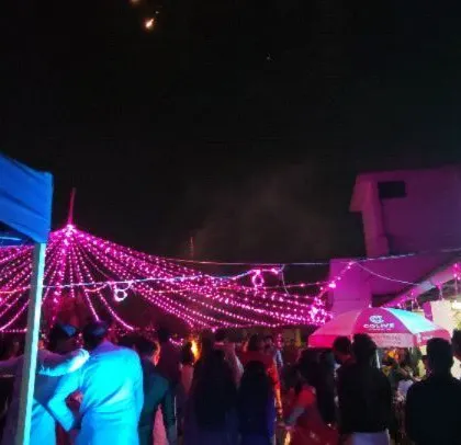 A wide view of the outdoor venue for the corporate Diwali party, showing the tent and lighting setup.