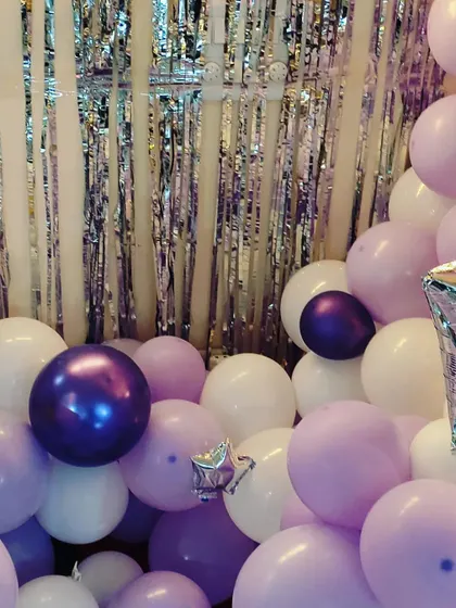 A close-up of the balloon arrangement, showing the mix of different shades of purple and white balloons used to create a soft and elegant look.