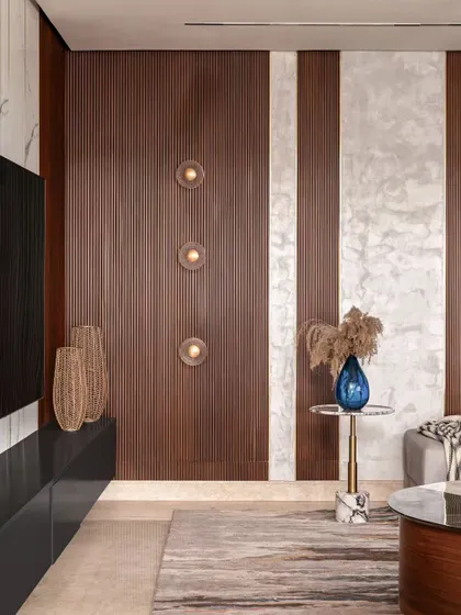 A close-up showing the interplay of textures. The fluted wood paneling, the marble-like wall finish, and the woven vases create a rich, tactile experience. The wall sconces add a warm, ambient glow.