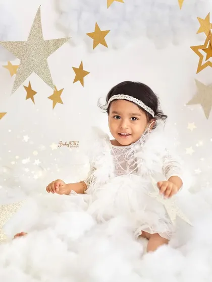 This little angel looks so sweet and serene sitting in a bed of fluffy clouds. It's a simple yet beautiful setup for a milestone session.