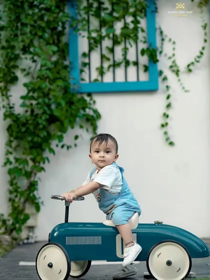 This little boy looks so happy on his vintage ride-on car. The bright colors and natural setting make for a beautiful photo.
