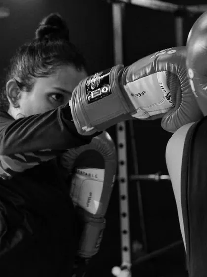 A powerful shot of a female boxer landing a punch. This captures the grit and determination we value at the club.