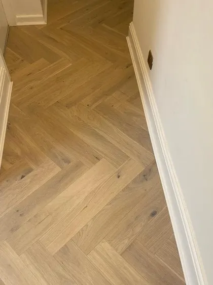 This close-up shows the detail of a herringbone wood floor I installed in a hallway. This pattern is excellent for creating a sense of movement and making narrow spaces feel more dynamic.