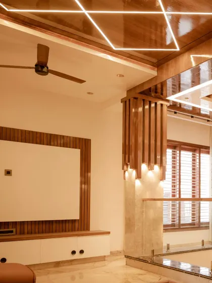 A wide shot showing the interplay of different lighting elements in this space, from the geometric ceiling to the pillar lights.