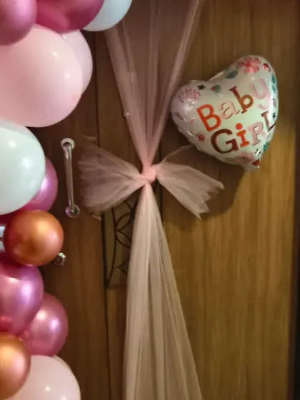 A beautiful door decoration for a baby girl's welcome home celebration. The pink tulle bow adds a soft, elegant touch to the balloon arrangement.