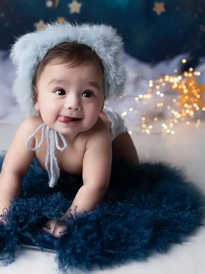 This little boy looks so curious and sweet against the starry night backdrop. The fuzzy blue hat and rug add a lovely texture to the celestial theme.