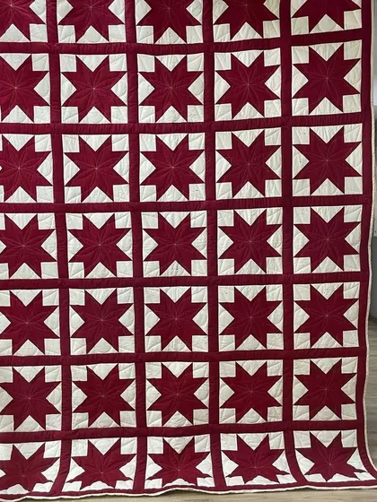 A simple and bold "Sawtooth Star" quilt in just two colors, red and white.