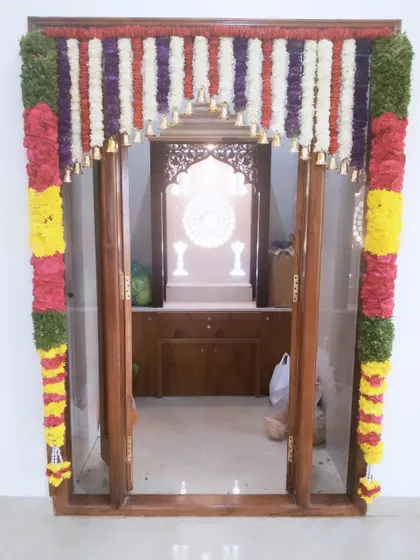 Another pooja room door decoration with vertical garlands and bells. This style is perfect for framing the entrance to your home's sacred space.