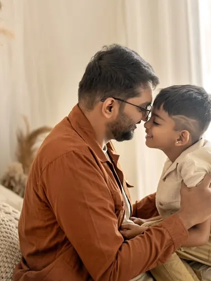 A quiet, tender moment between a father and son. The gentle touch and shared smile speak volumes about their bond, a beautiful memory captured forever.
