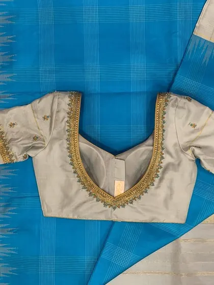 A grey hand-embroidered silk blouse paired with a cobalt blue and grey silk saree.
