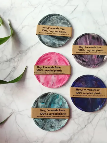 Our recycled plastic coasters are designed to protect your table while making a statement. Each coaster is wrapped in a simple paper band that proudly states, "Hey, I'm made from 100% recycled plastic."