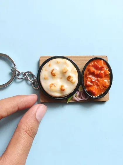 A close-up of a naan and curry keychain, a perfect gift for any North Indian food lover.