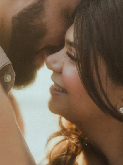 An extreme close-up capturing the joyful smiles and intimacy of a couple during their beach photoshoot. This shot focuses purely on their happy connection, making for a powerful, emotional portrait.