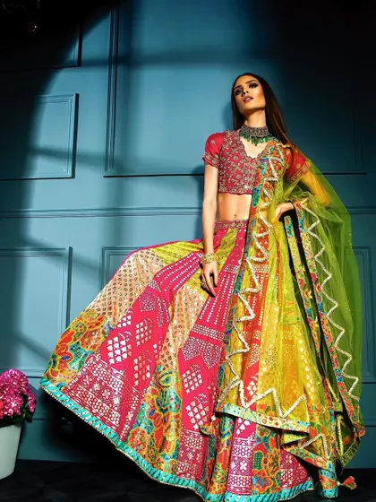 A powerful pose in a vibrant multi-colored lehenga. The strong lighting from the side highlights the model's form and the texture of the skirt, creating a striking image for a model's portfolio.