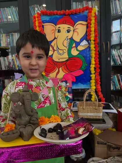 A young artist proudly displays his eco-friendly Ganesha idol, complete with seeds inside, ready for a sustainable celebration.