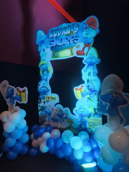 The Smurfs photo booth frame shown in a darker setting with blue lighting to create a magical atmosphere.