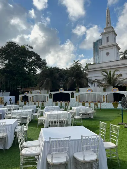 A daytime view of an outdoor event setup, with crisp white table linens and a beautiful natural backdrop.