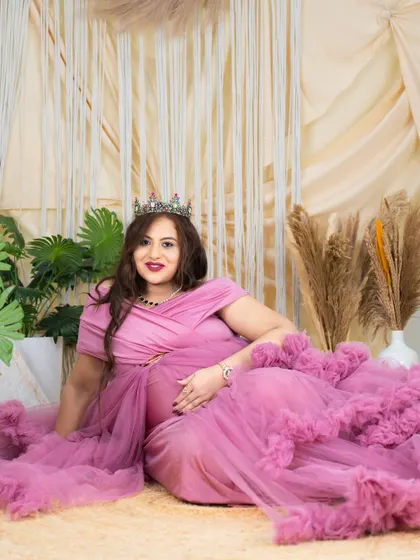 A relaxed yet regal portrait. The mom-to-be is lying on the floor of our boho studio in a beautiful pink gown, looking confident and serene.