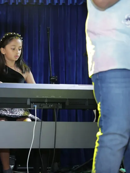 A young pianist performs with grace and concentration. Our curriculum, which includes Trinity College London exam prep, builds a strong technical foundation.