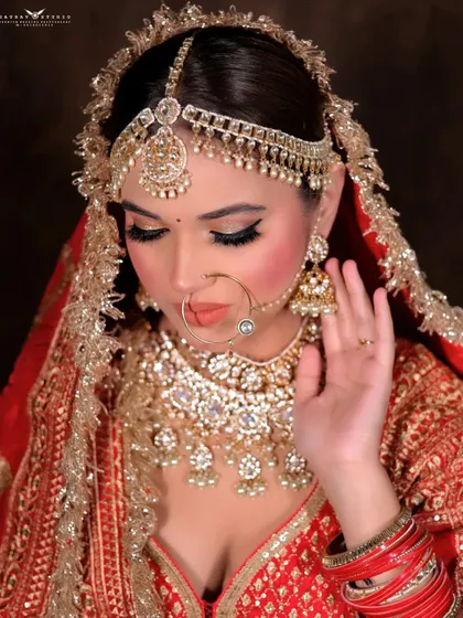 A serene portrait with the bride's eyes closed, showcasing the detailed eye makeup and the sparkle of her maang tikka and nath.