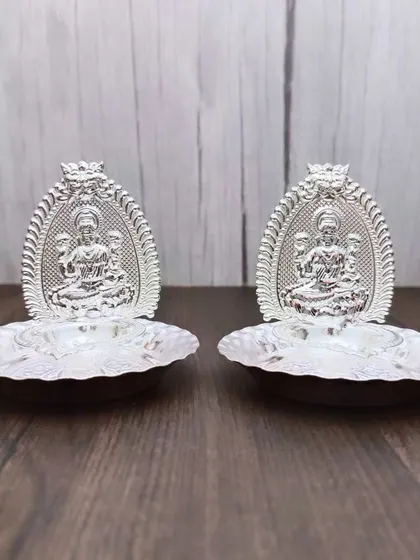 A pair of German silver Lakshmi arch diyas. These small, elegant lamps are perfect for placing on a thali or at a small home shrine.