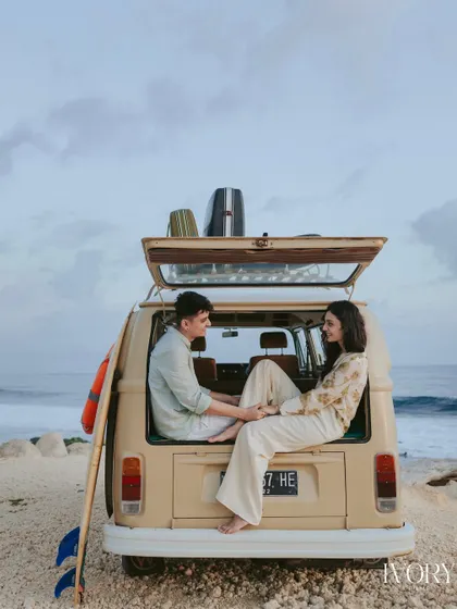 A cozy moment captured in the back of a vintage camper van in Bali. This shot tells a story of shared adventure and quiet intimacy, with the ocean just visible in the background.