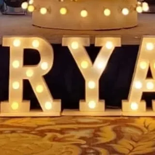 These light-up marquee letters spelling 'RYA' are perfect for personalizing a birthday party or any other celebration. They add a bright and custom touch to the stage or entrance decor.