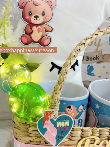 A close-up on the charming details of the moon-themed hamper, including the glowing decorative balls, a teddy bear sticker, and a "MOM" heart tag.