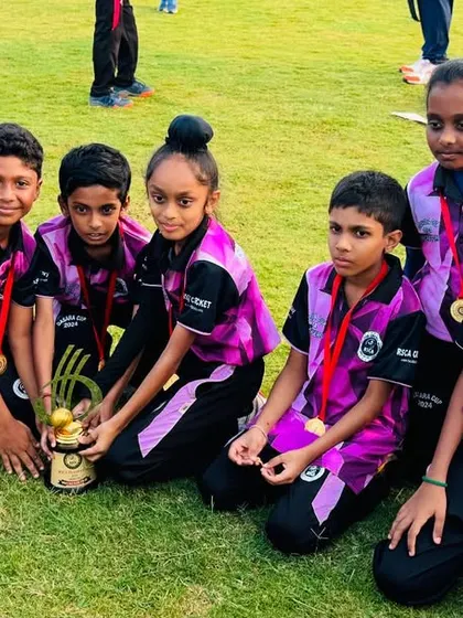 The youngest players gather around their championship trophy with their medals.