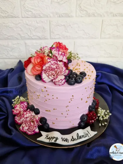 A beautiful floral cake is always a good idea. This design is loaded with fresh flowers and berries, creating a vibrant and lush look that's perfect for any celebration.
