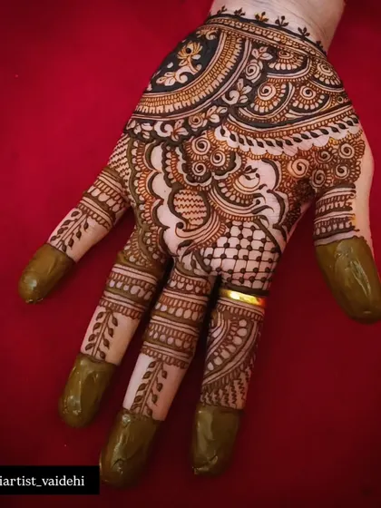 A close-up of a party mehendi design with a mix of checks, florals, and paisleys. The use of negative space makes the design pop.