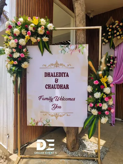 Another view of the stylish welcome sign, showing how it integrates with the venue's wooden textures. The combination of modern design and fresh flowers creates a warm and inviting first impression.